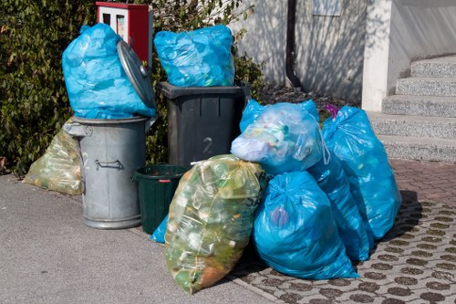 Crew loading garden waste into a collection vehicle with safety markers